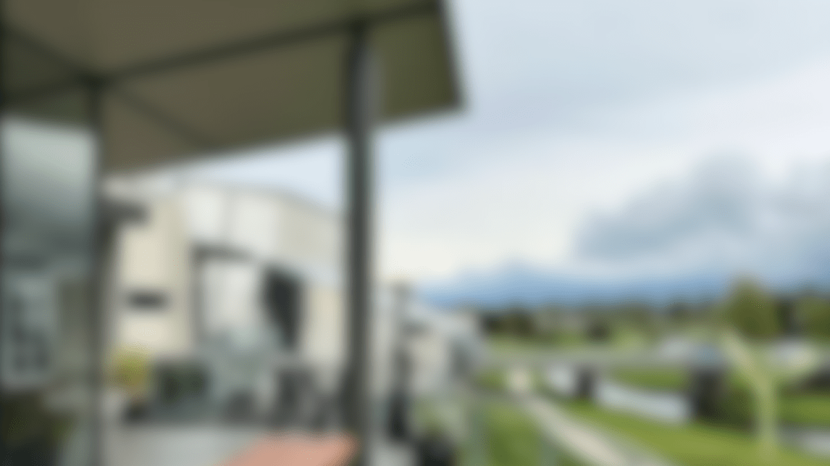 Blurred image of a patio with a picnic table and lawn in the background.